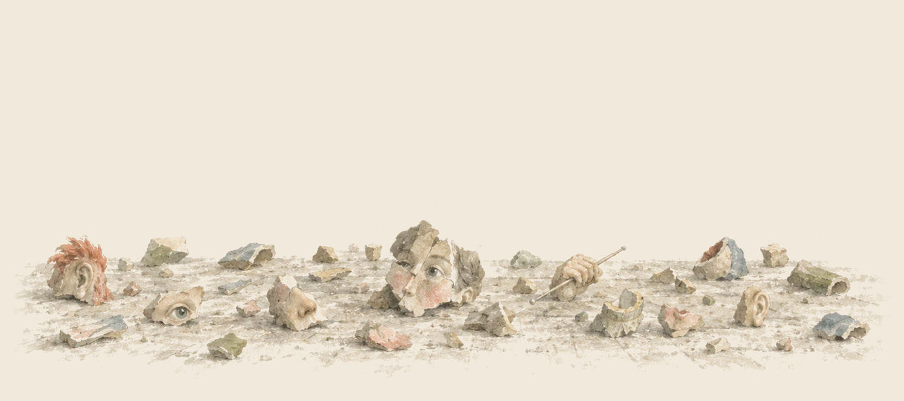 Scattered pieces of the Fuddles lie across a bare floor, among them eyes, noses, ears, a hand holding a knitting needle and one nearly joined face.