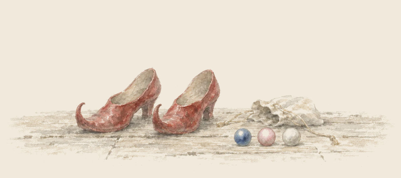 A pair of pointed red shoes stands beside a small open bag and three pearls in a row: one blue, one pink and one white.