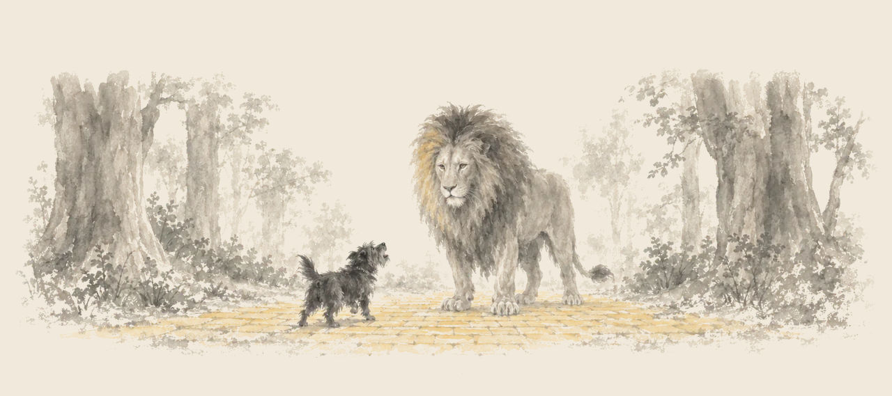 The Cowardly Lion stands in the yellow brick road between forest trees, while Toto barks up at him.