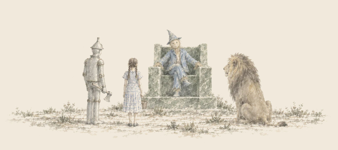 The Scarecrow sits on the green marble throne as the Tin Woodman, Dorothy and the Cowardly Lion stand before him.